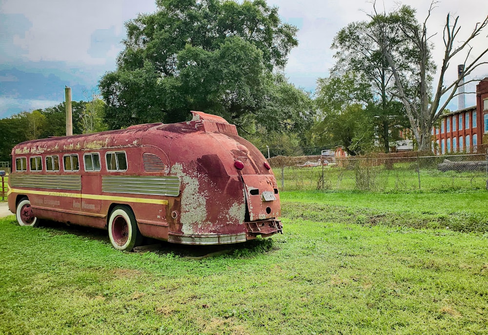 an old school bus sitting in a grassy field