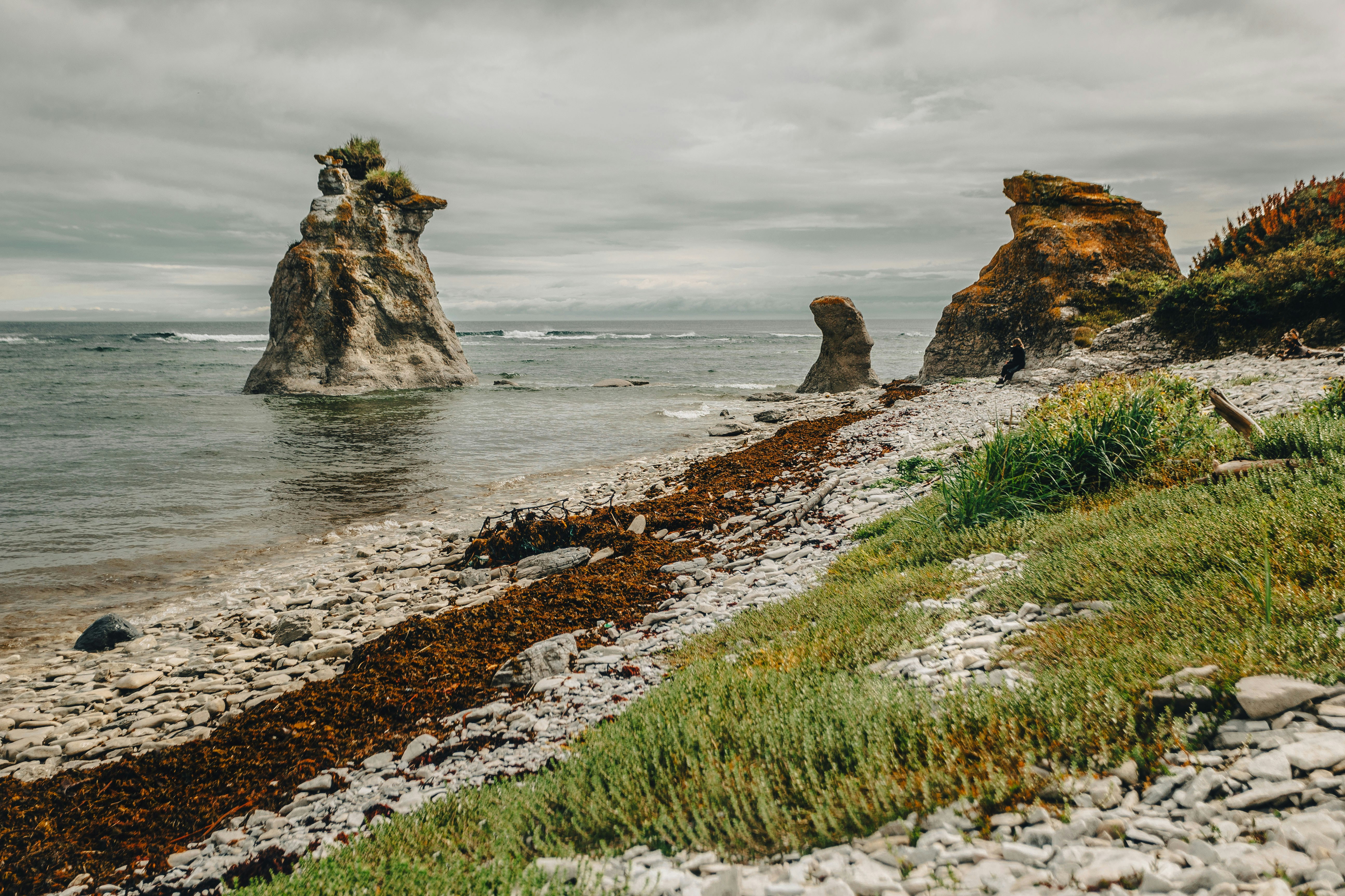 Ein felsiger Strand mit einer Felsformation in der Ferne
