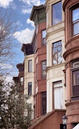 a row of multi - story buildings with a clock on the front