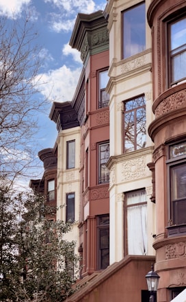 a row of multi - story buildings with a clock on the front