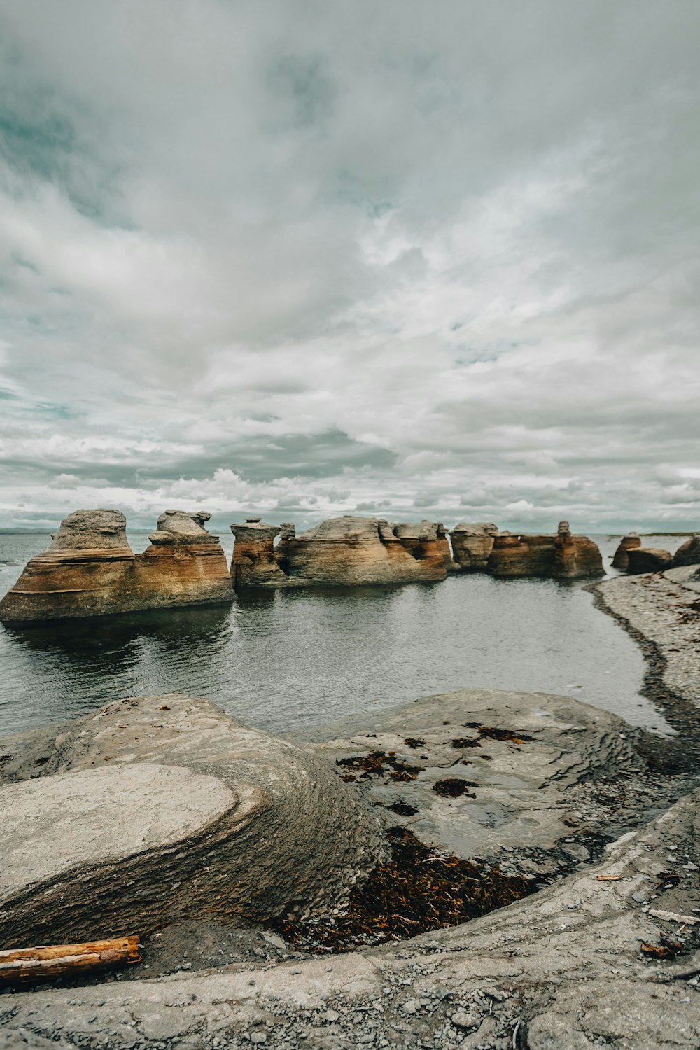 a body of water surrounded by rocks under a cloudy sky