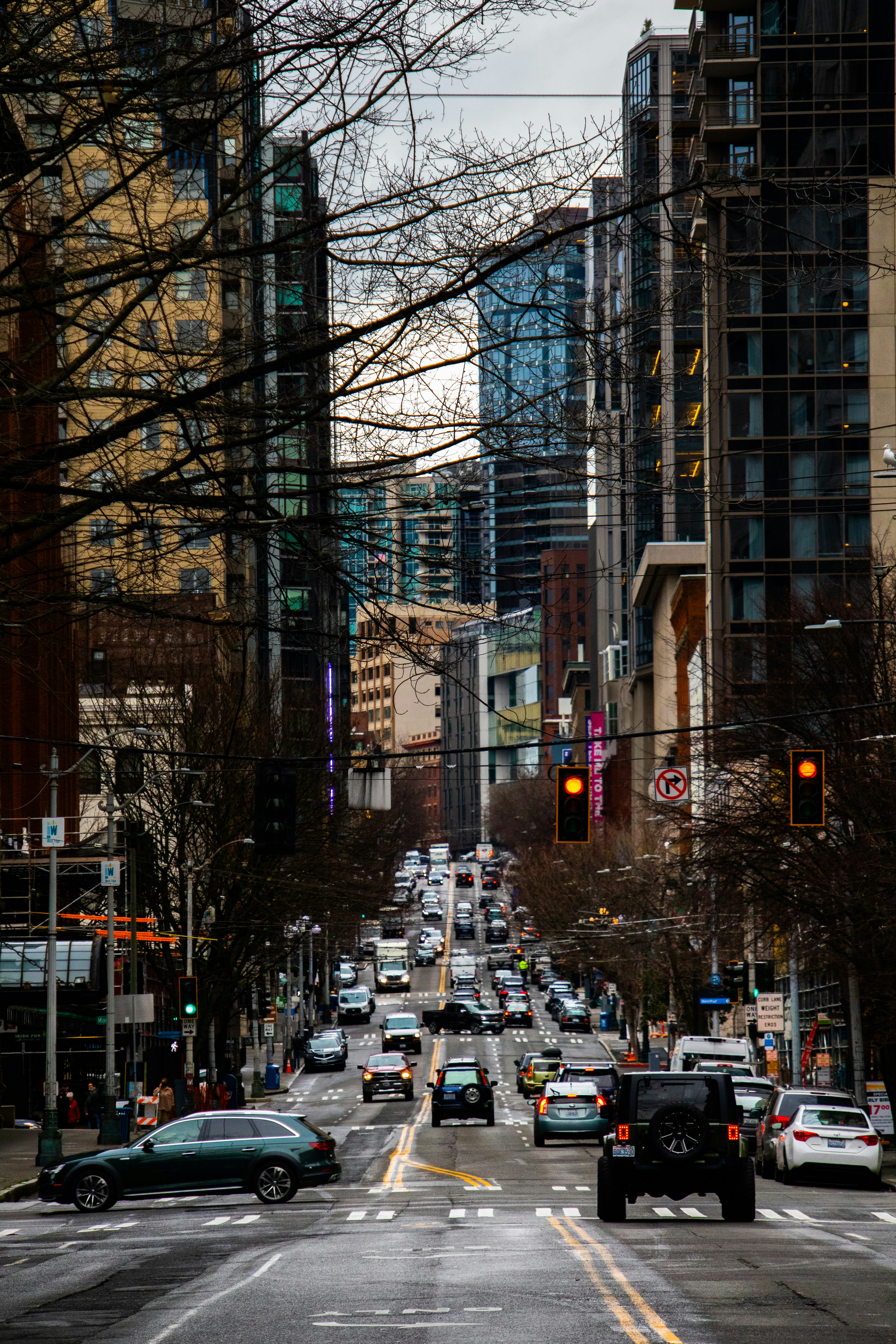 Una calle de la ciudad llena de mucho tráfico junto a edificios altos foto  – Imagen de Coche gratuita en Unsplash, image size:3000x4500