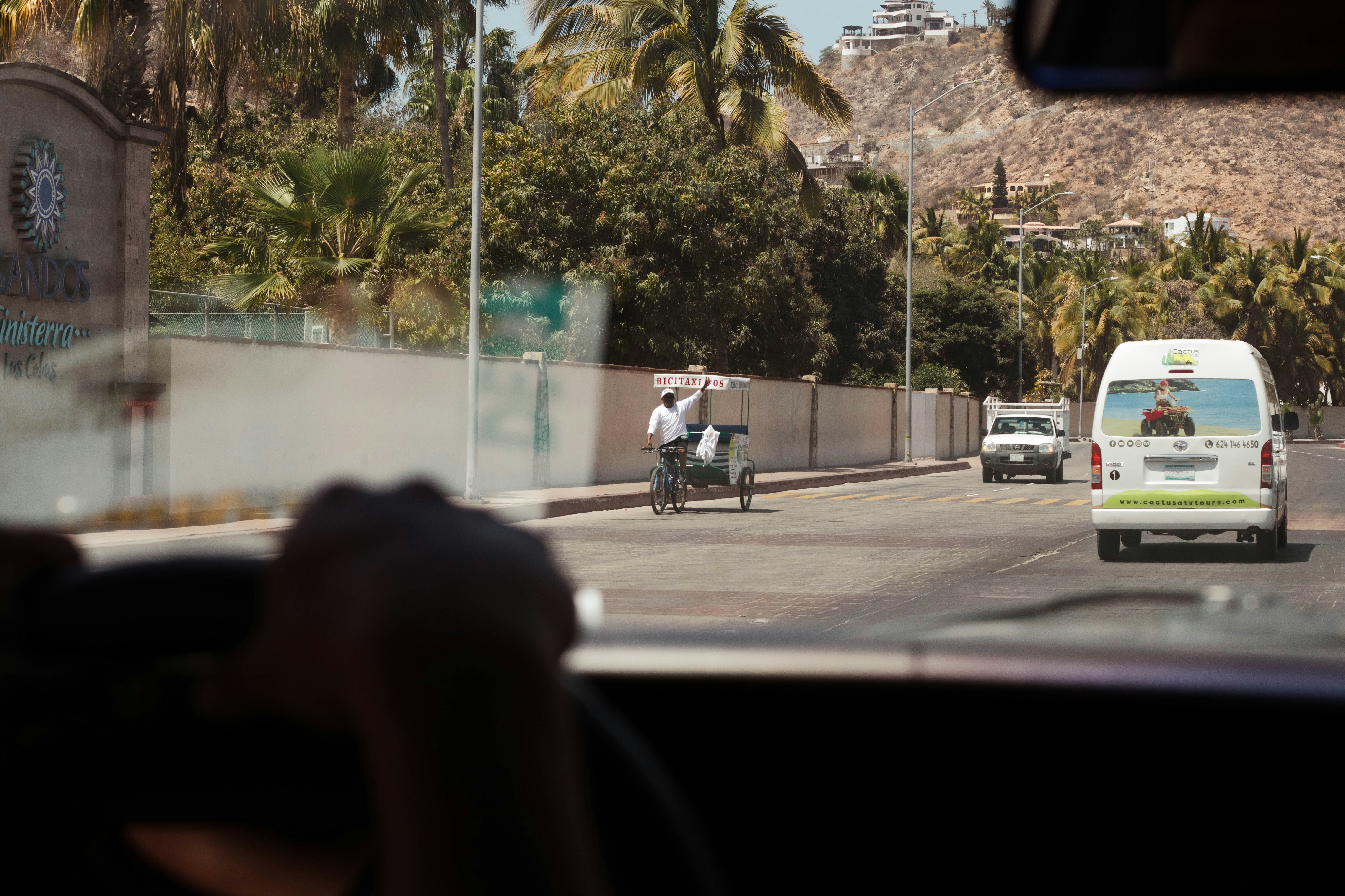 Ein Mann fährt mit einem Motorrad eine Straße entlang neben einem weißen Lieferwagen