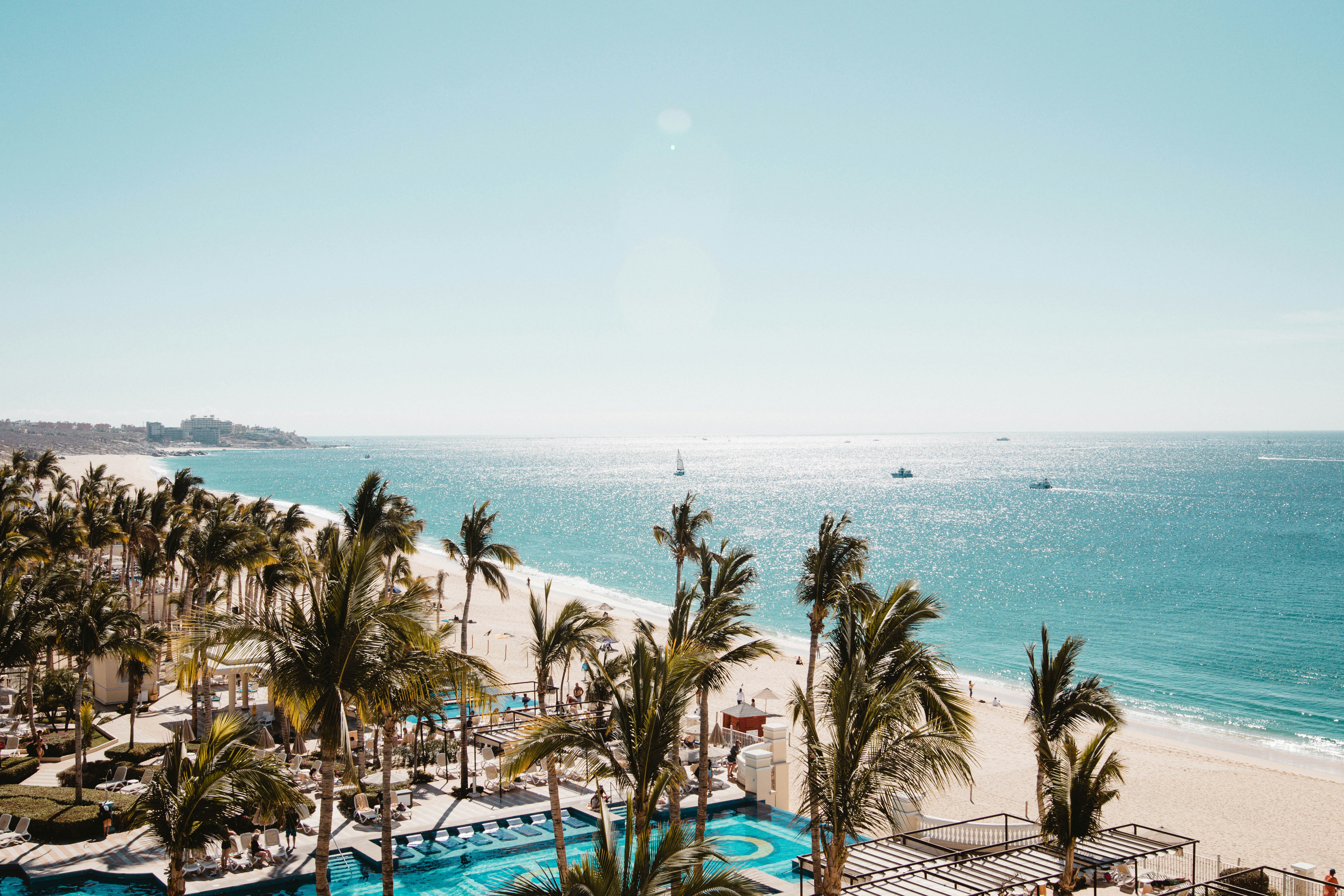 Eine Luftaufnahme eines Strandes mit Pool und Palmen