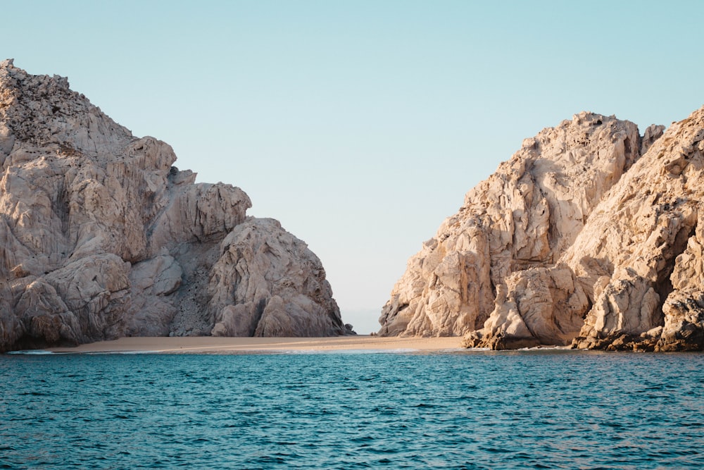 a large rock formation in the middle of a body of water