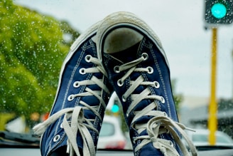 a pair of blue sneakers sitting on the dashboard of a car
