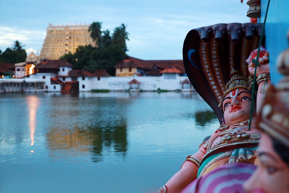 a statue of a woman sitting next to a body of water