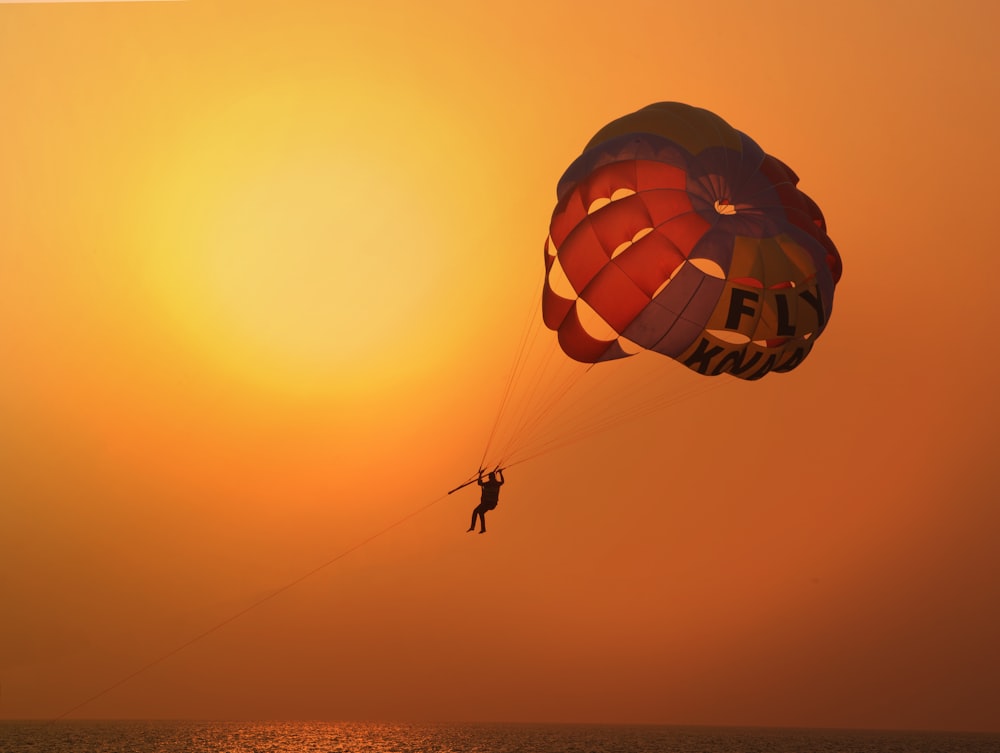 a person is parasailing in the ocean at sunset