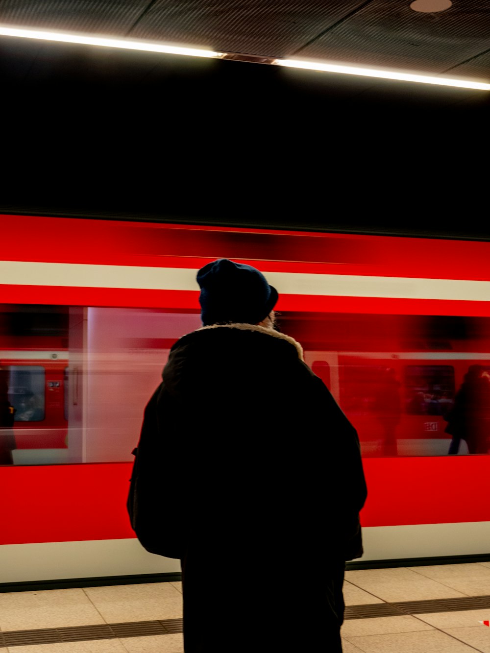 a person standing in front of a red train