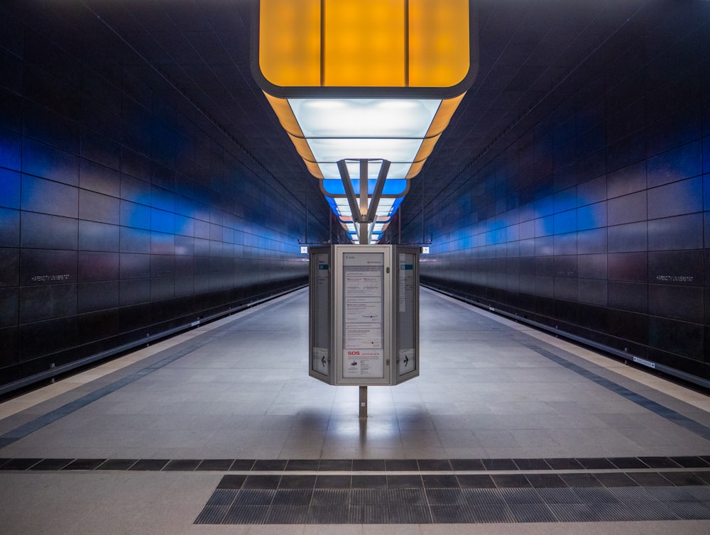 a long hallway with a phone booth in the middle of it