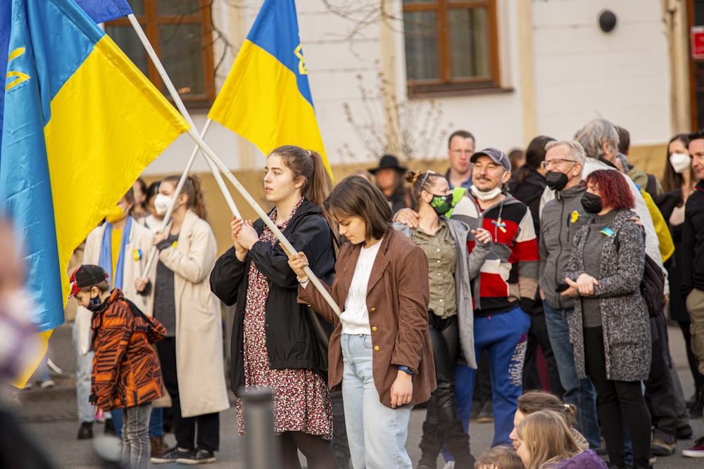 a group of people standing around each other holding flags