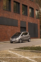 A compact economical car parked in front of a modern building.