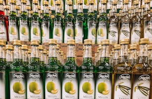 many bottles of alcohol are stacked on a shelf