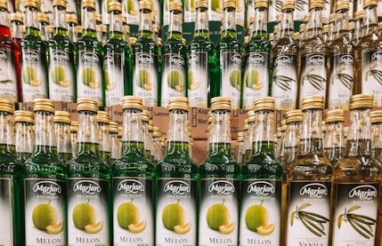many bottles of alcohol are stacked on a shelf