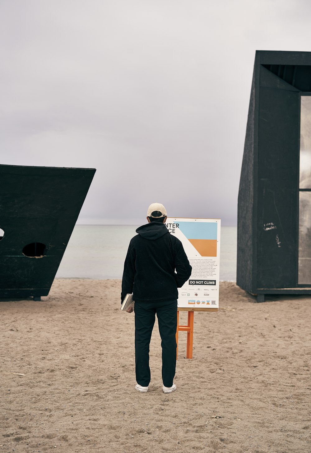 a man standing in front of a sign on the beach