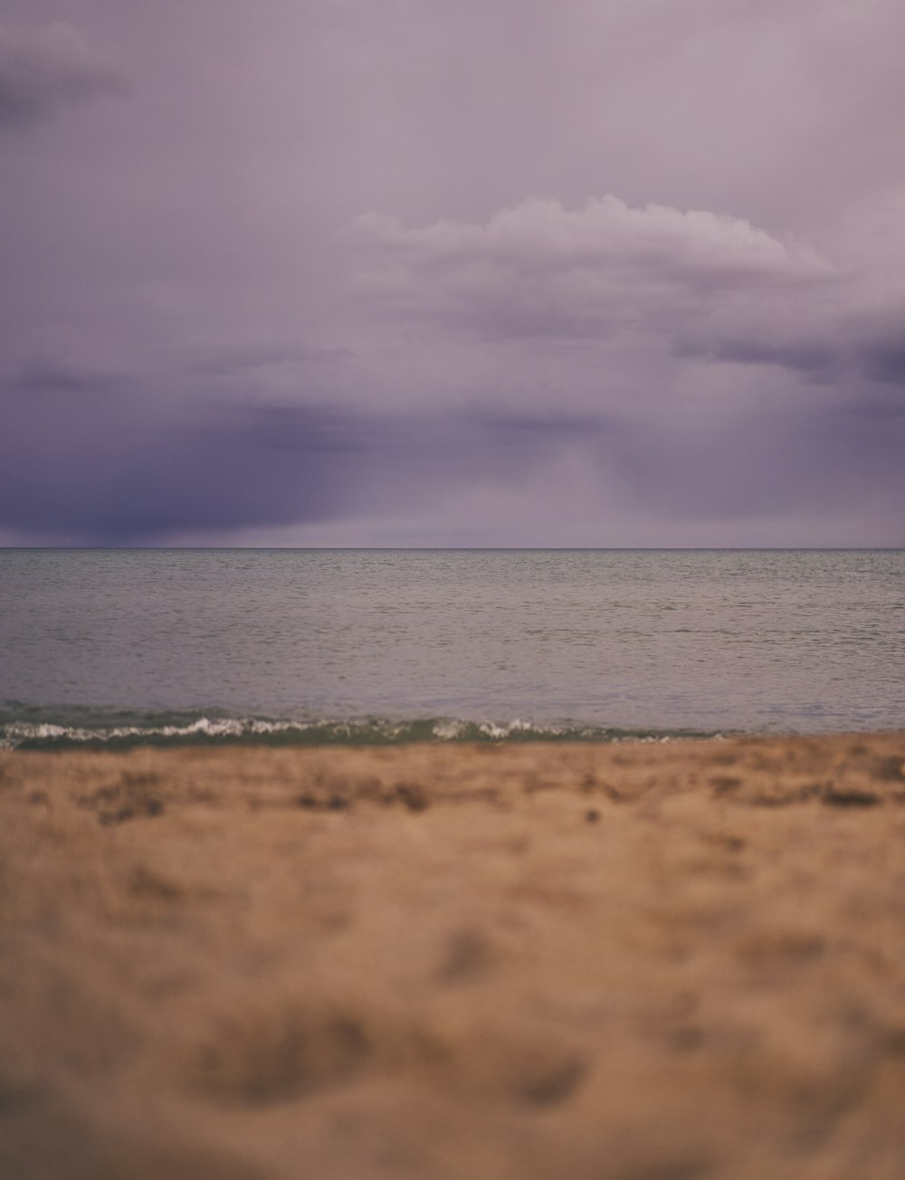 a person walking on the beach with a surfboard