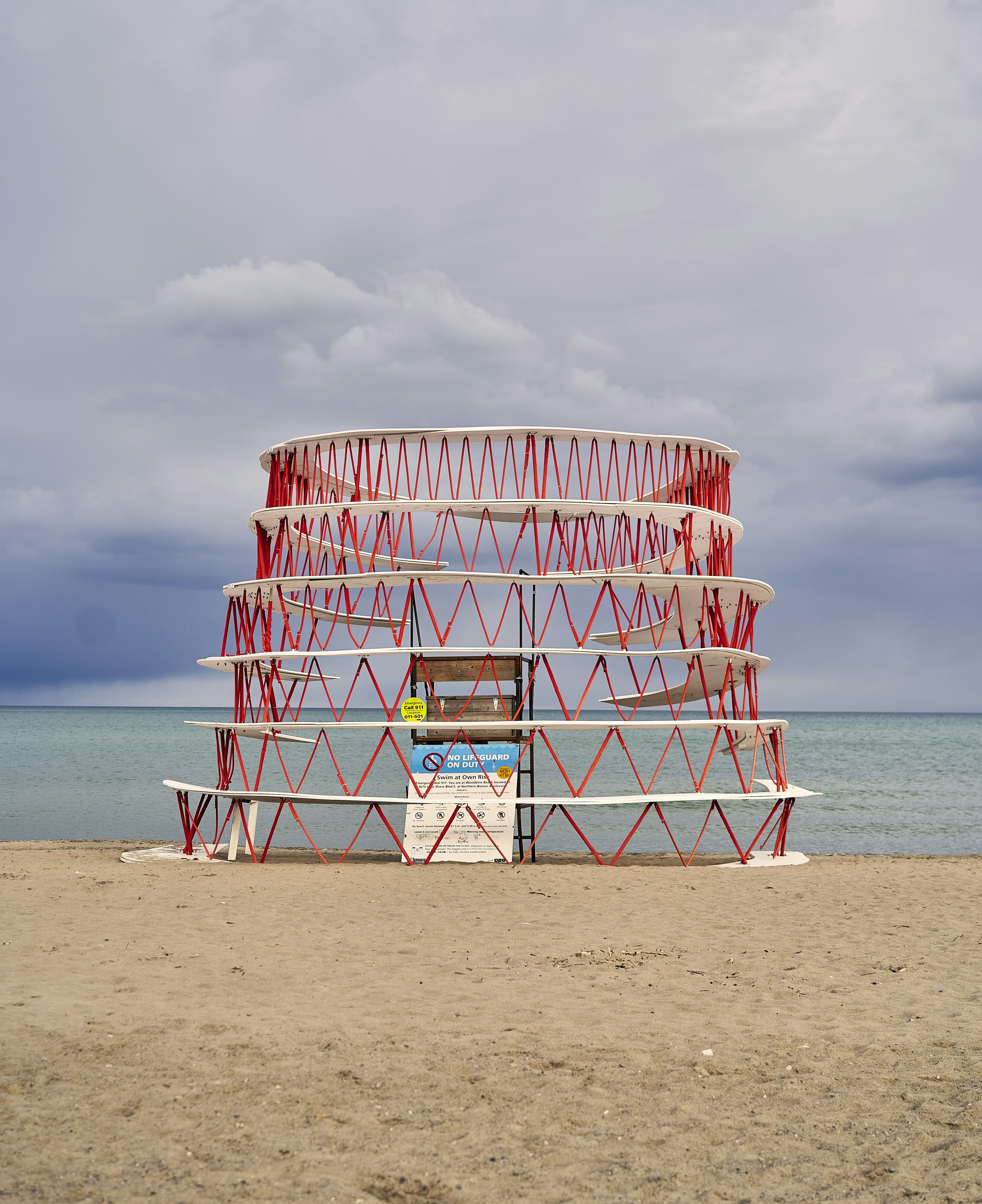 a red and white structure sitting on top of a sandy beach