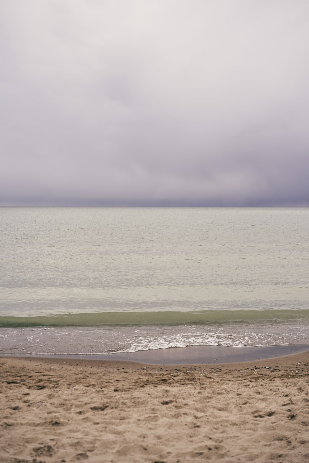 Eine Person, die mit einem Surfbrett am Strand spazieren geht