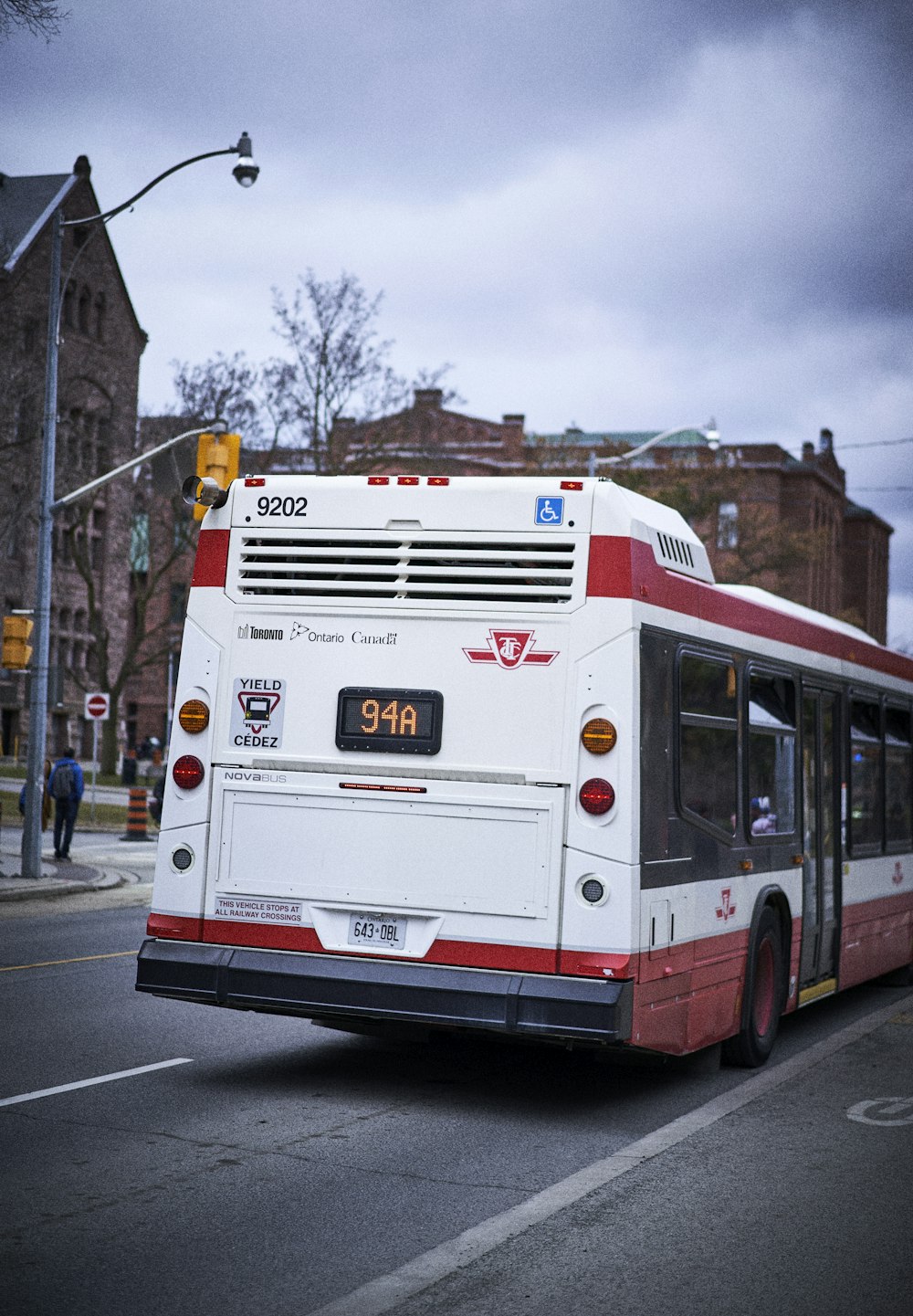 a red and white bus driving down a street