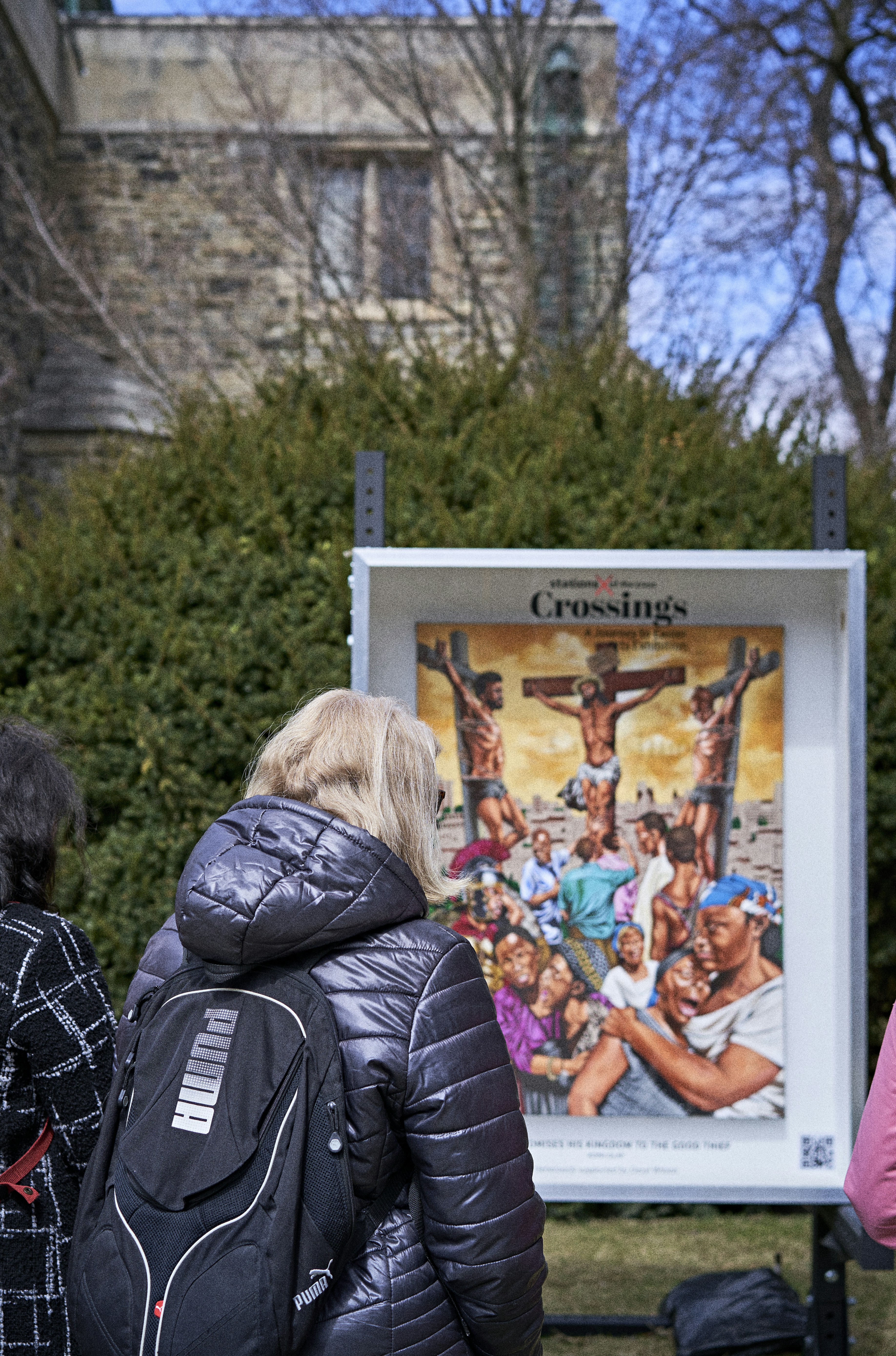 a group of people standing in front of a cross sign