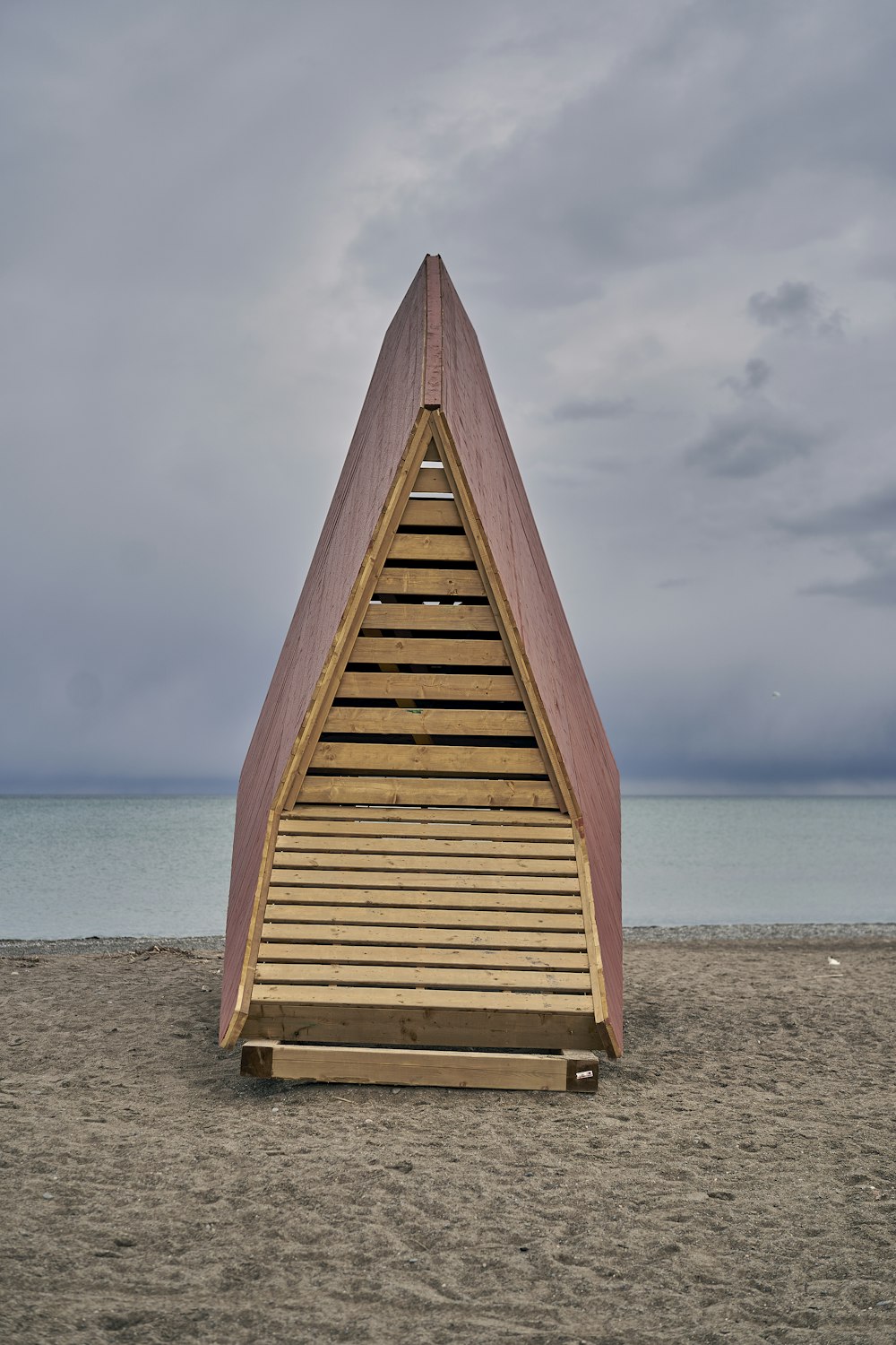una estructura de madera sentada en la parte superior de una playa de arena