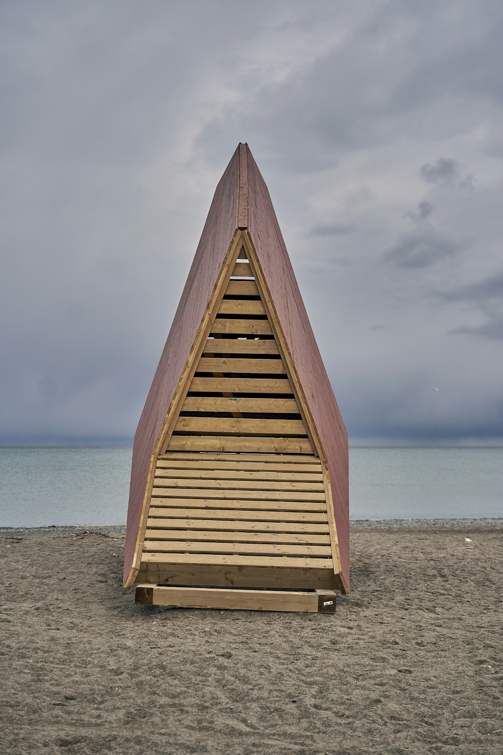 a wooden structure sitting on top of a sandy beach