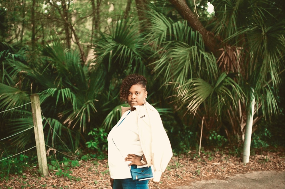 a woman standing in front of some trees