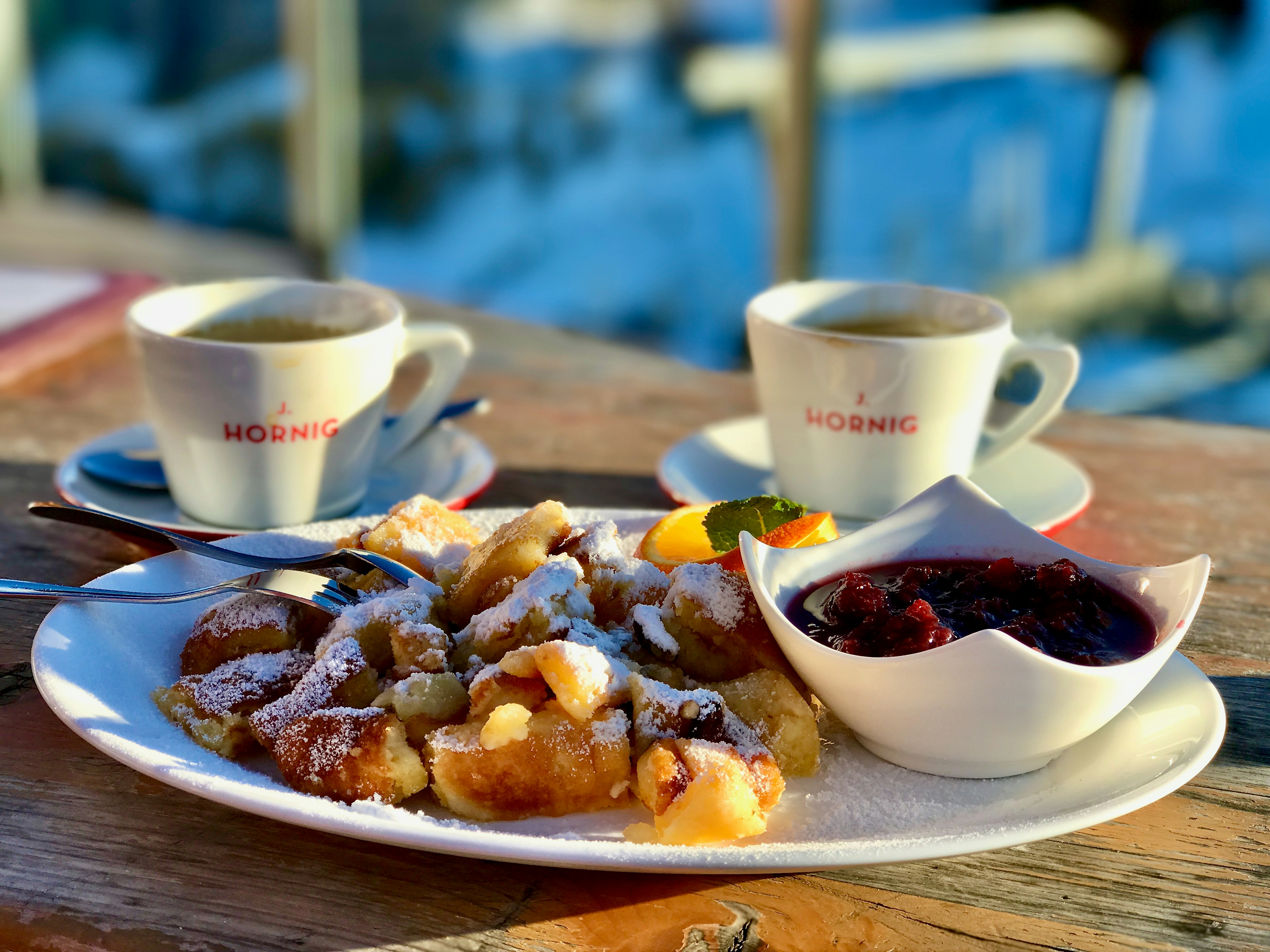 a white plate topped with dessert next to cups of coffee