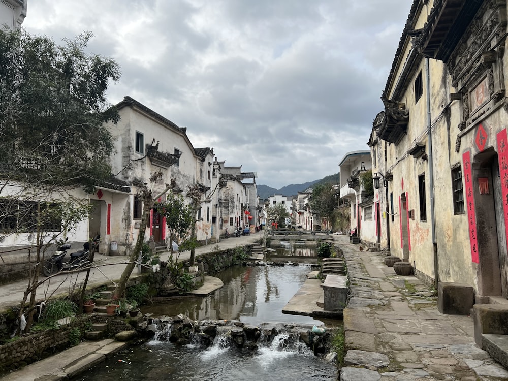 a river running through a small town next to tall buildings