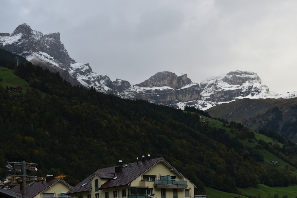 a group of houses in front of a mountain range