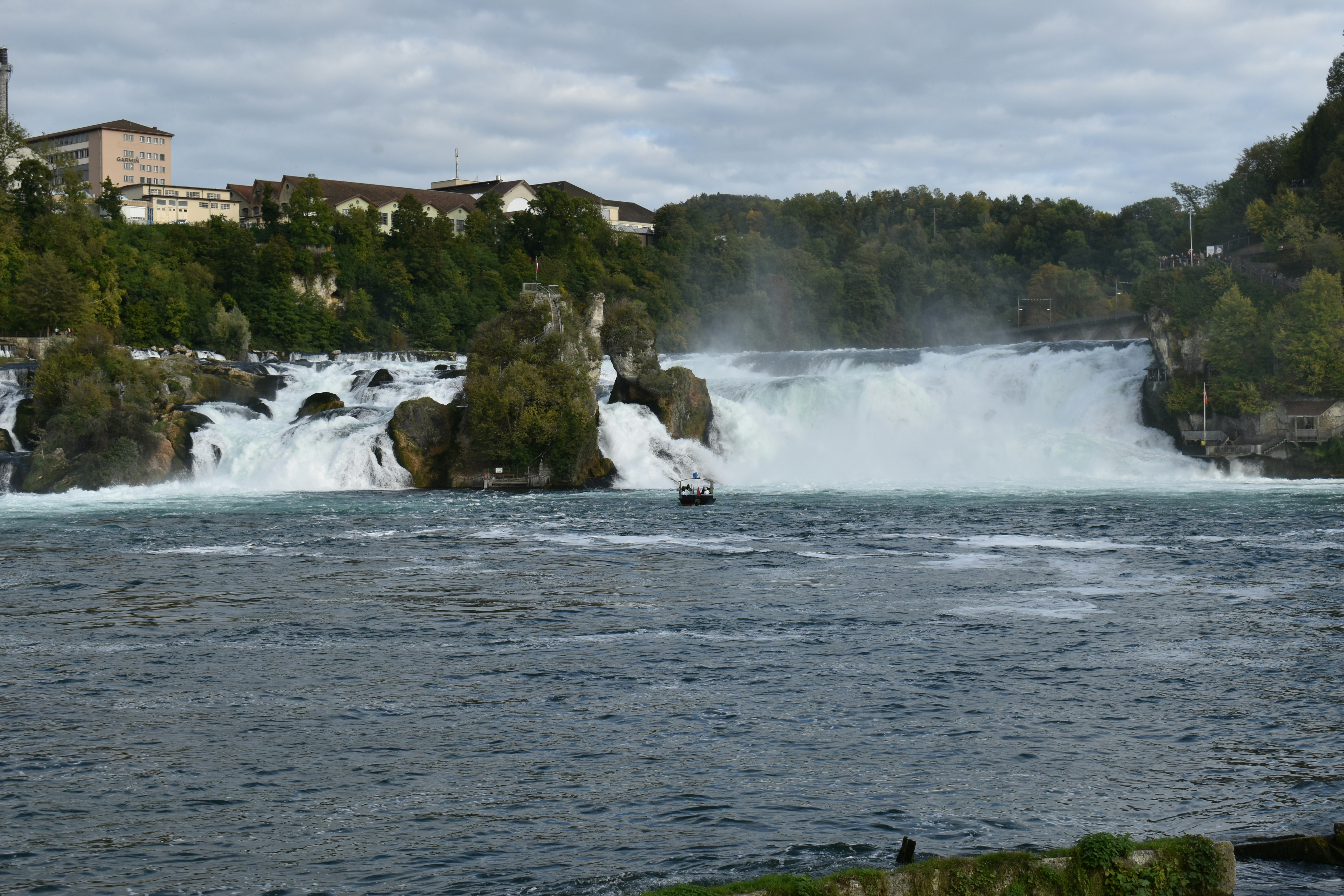 a boat is in the water near a waterfall