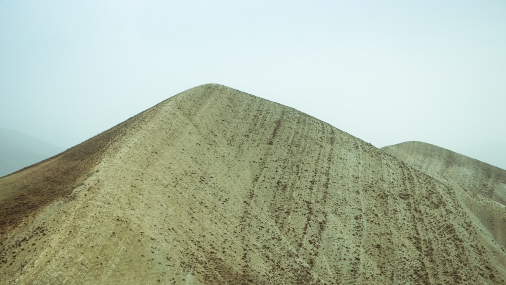 a very tall hill with a sky in the background