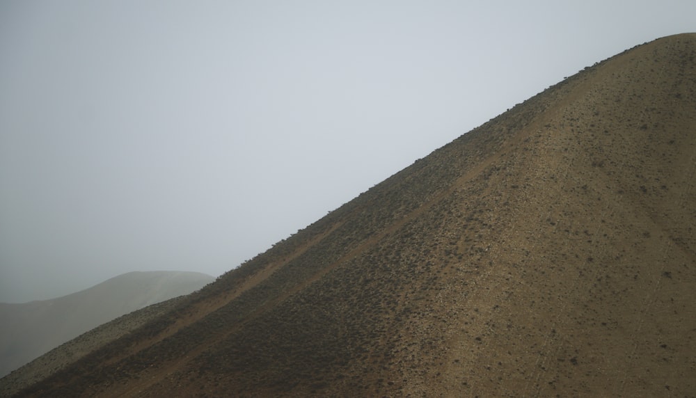 a hill covered in dirt with a sky background