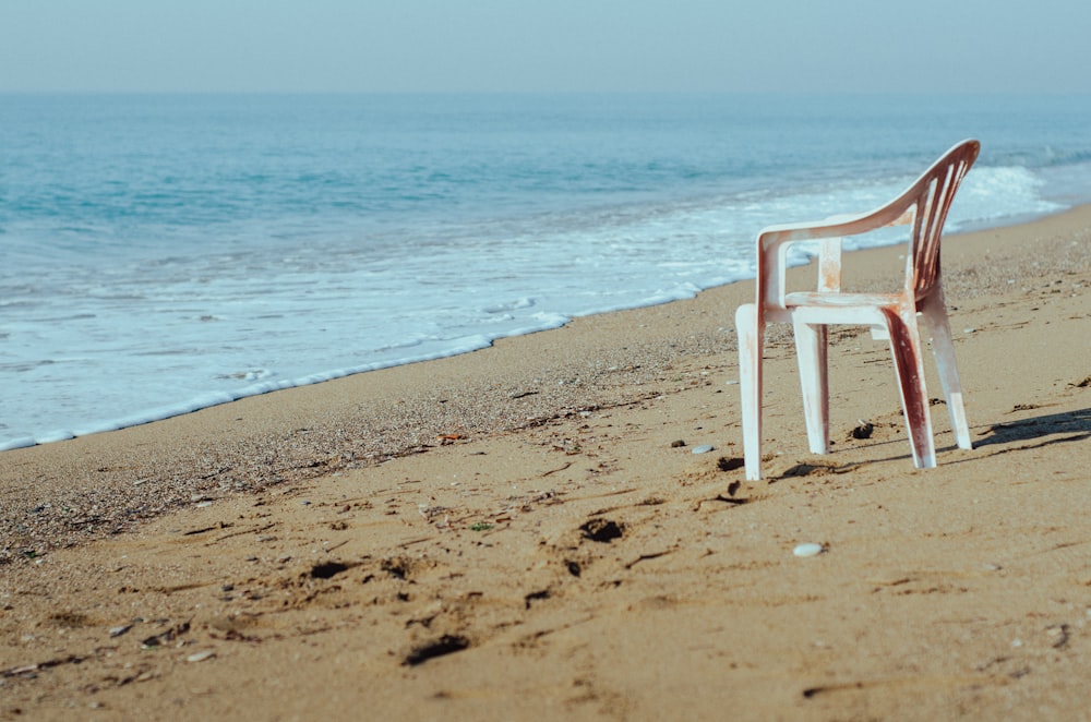a chair sitting in the sand on a beach