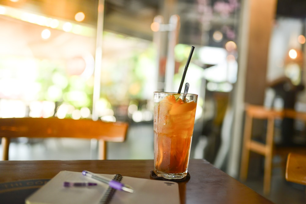 a drink and notebook on a table in a restaurant