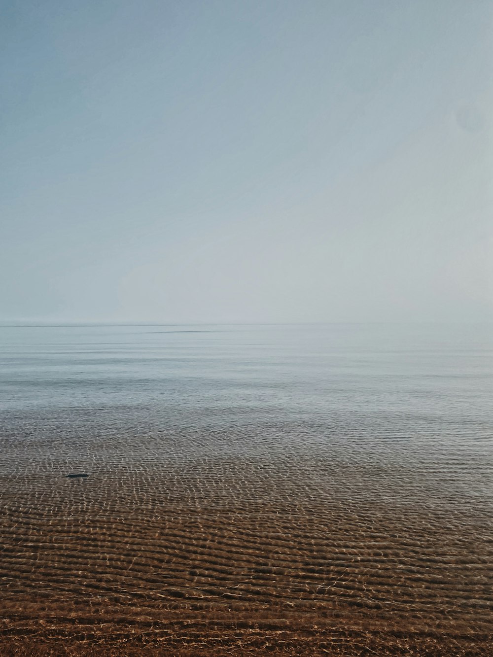 a lone boat floating on top of a large body of water