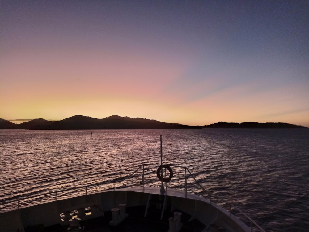 Le soleil se couche sur un bateau dans l’eau