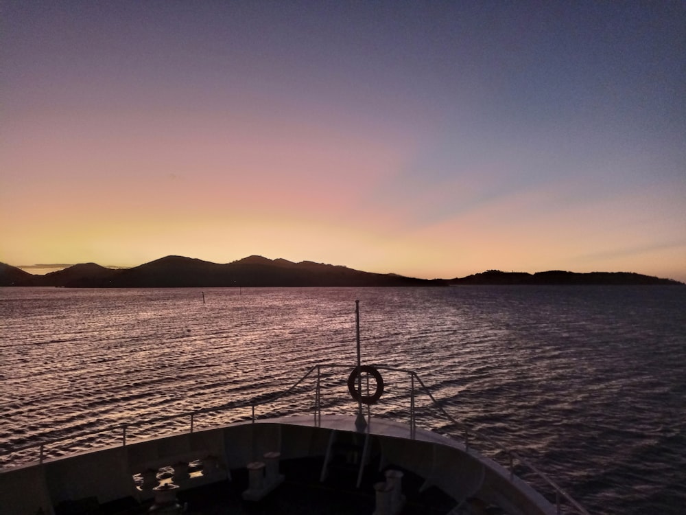 the sun is setting on a boat in the water