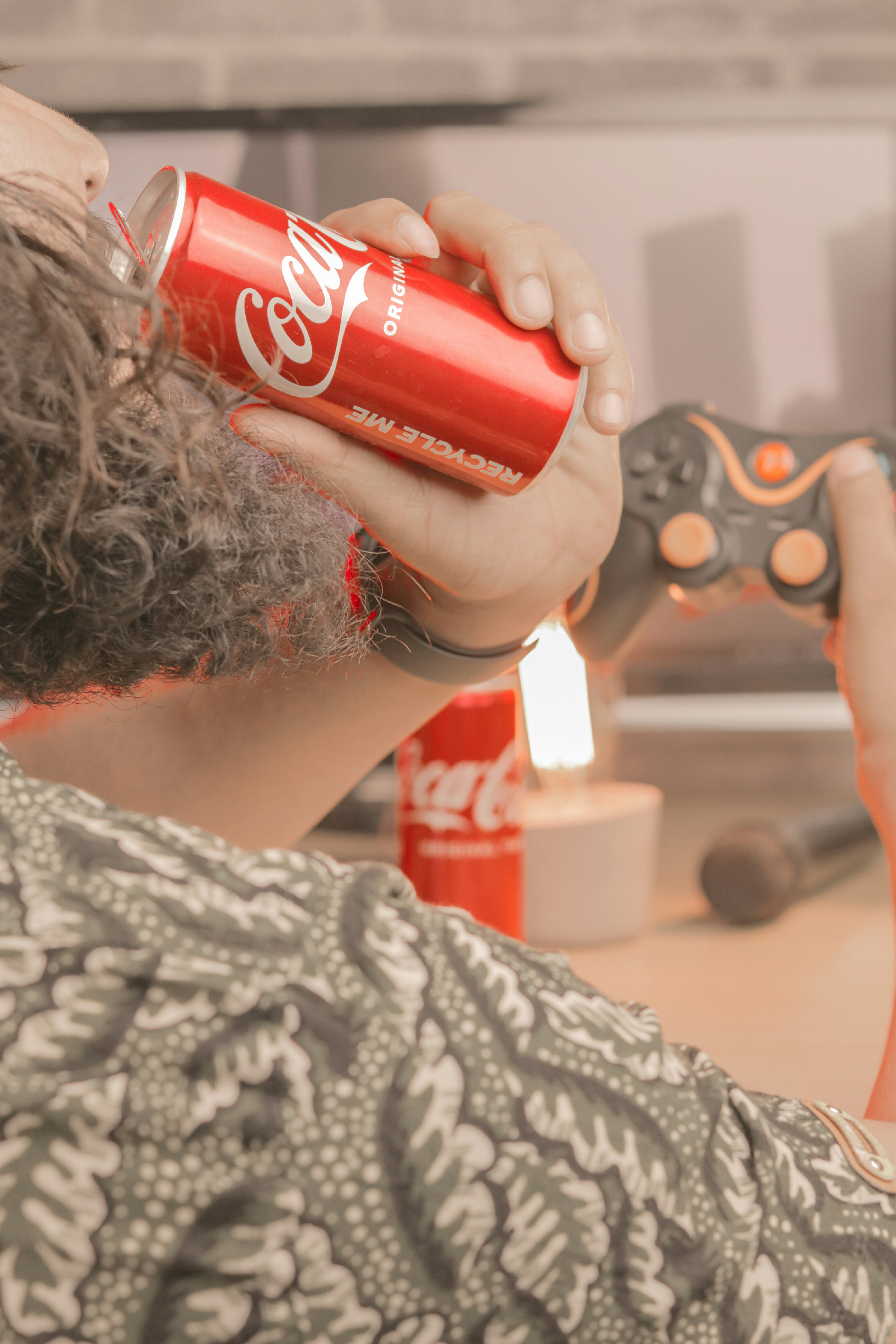 a man holding a can of coca - cola in his hand