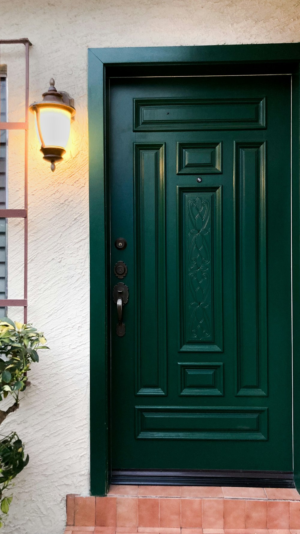 uma porta da frente verde em uma casa branca
