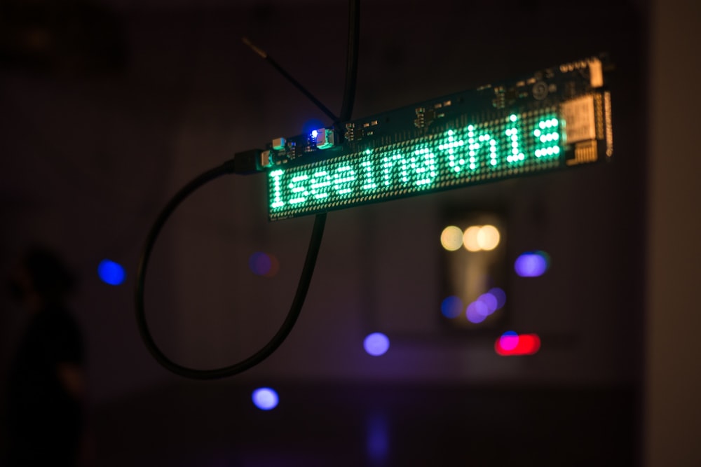 a green street sign hanging from the side of a building