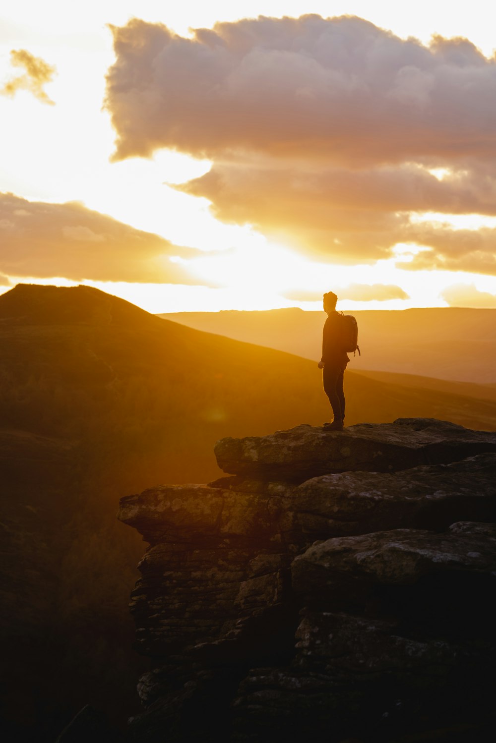 a person standing on top of a mountain at sunset