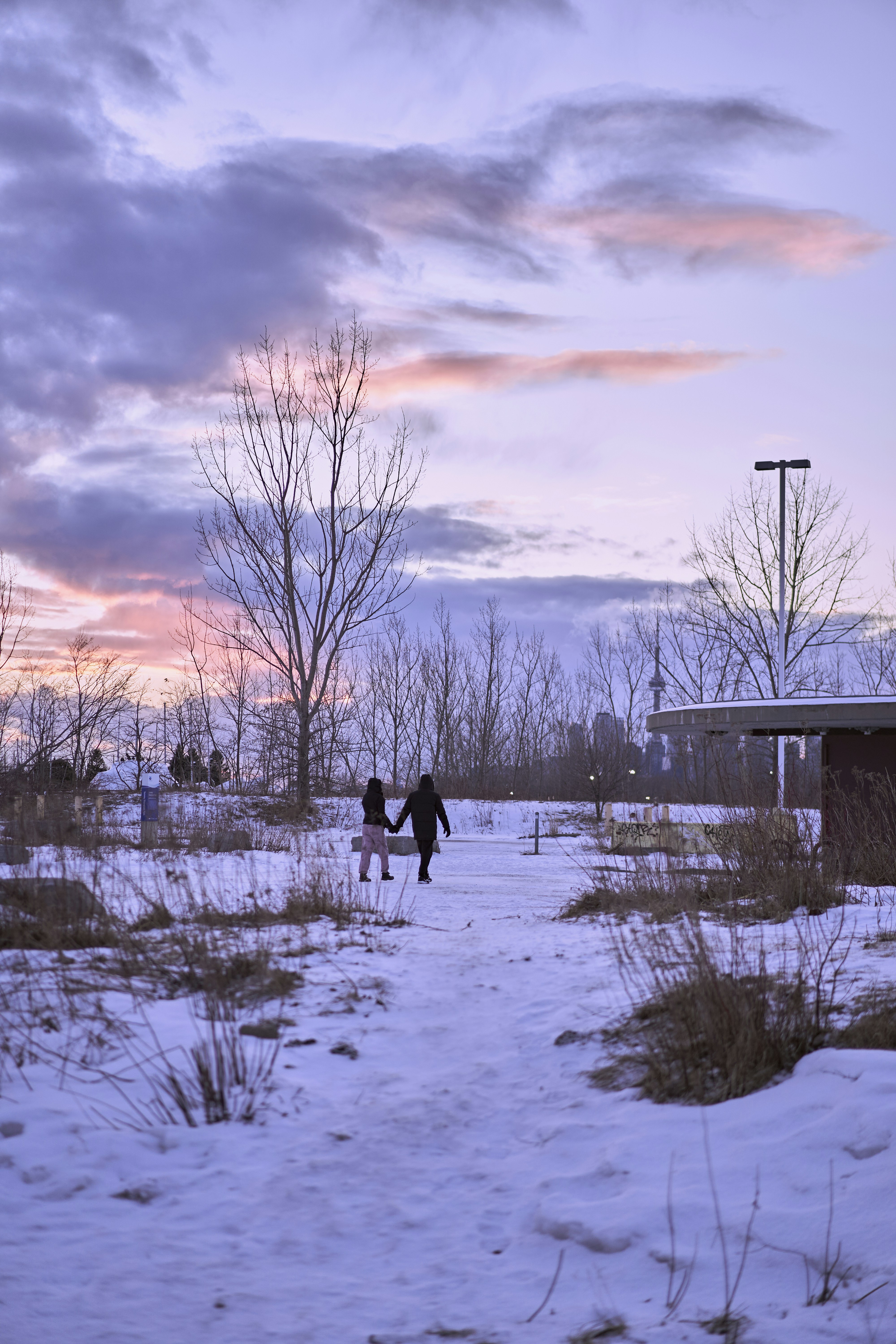 a couple of people walking across a snow covered field