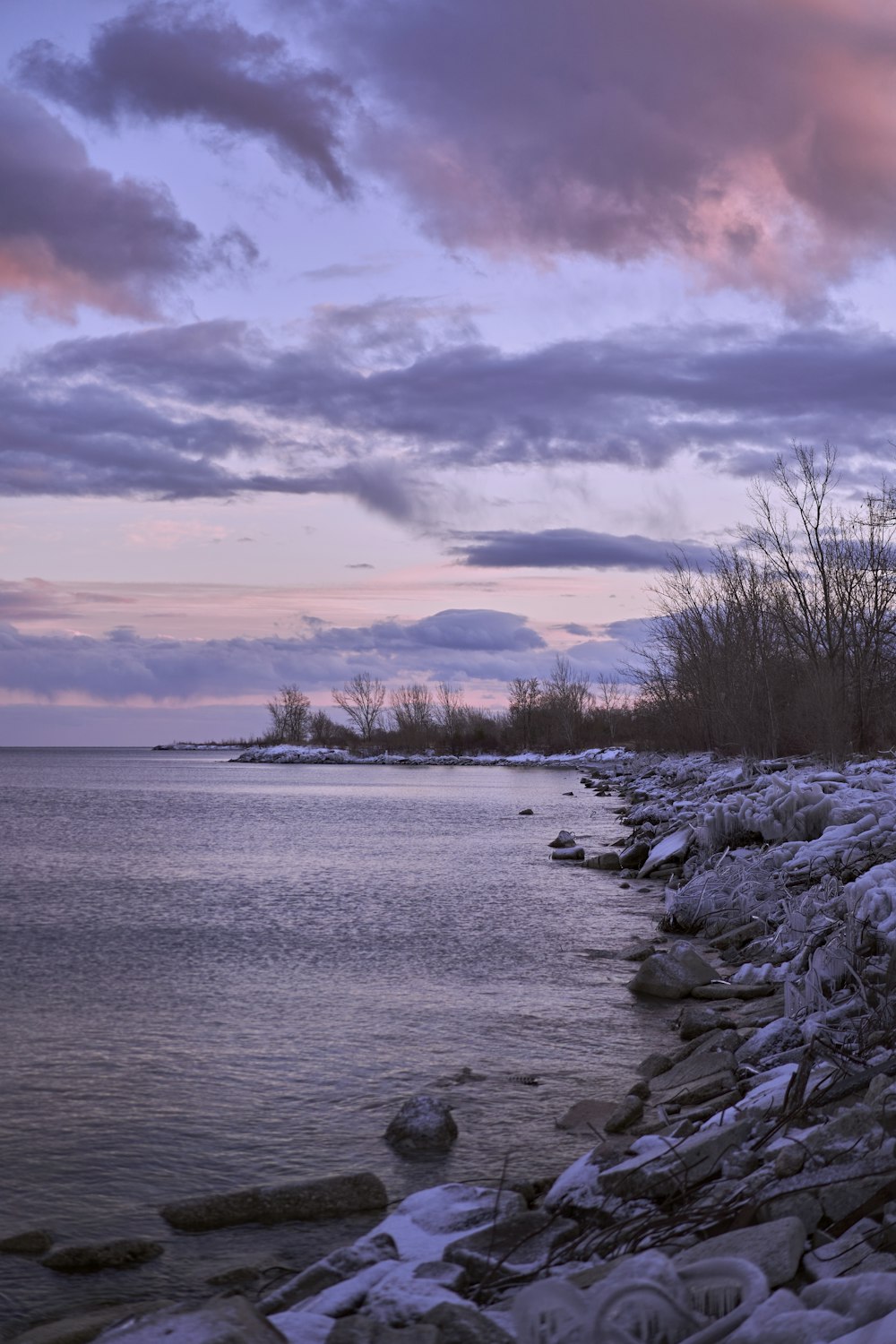 a body of water surrounded by rocks under a cloudy sky