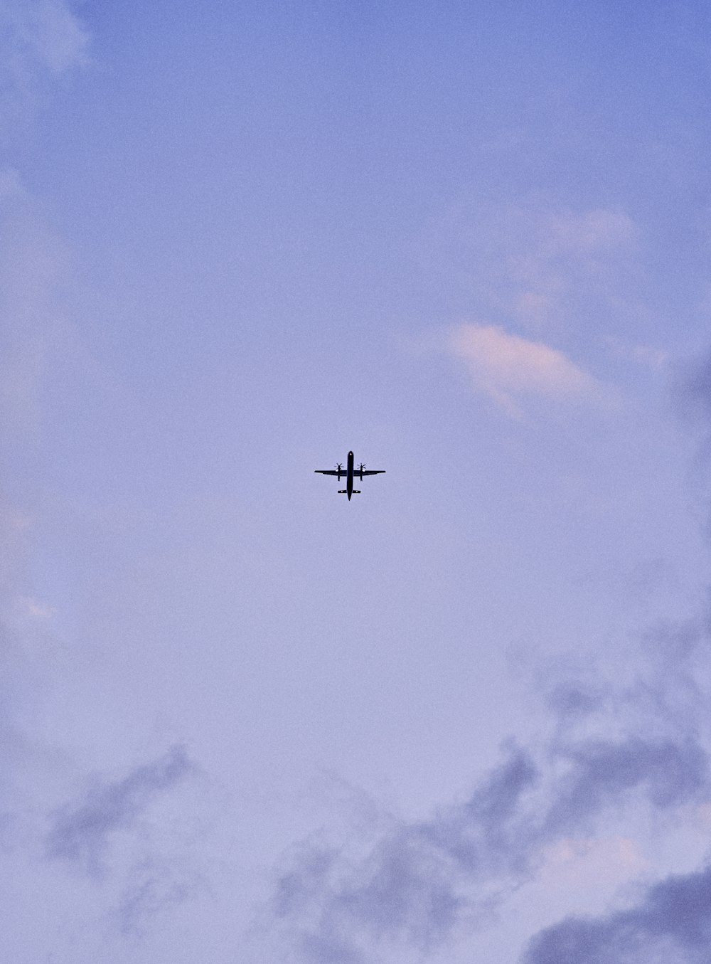 an airplane is flying in the sky with clouds