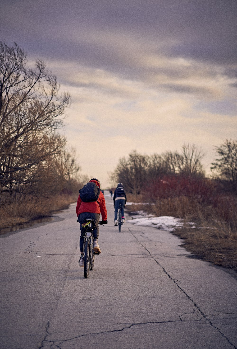 a couple of people riding bikes down a road