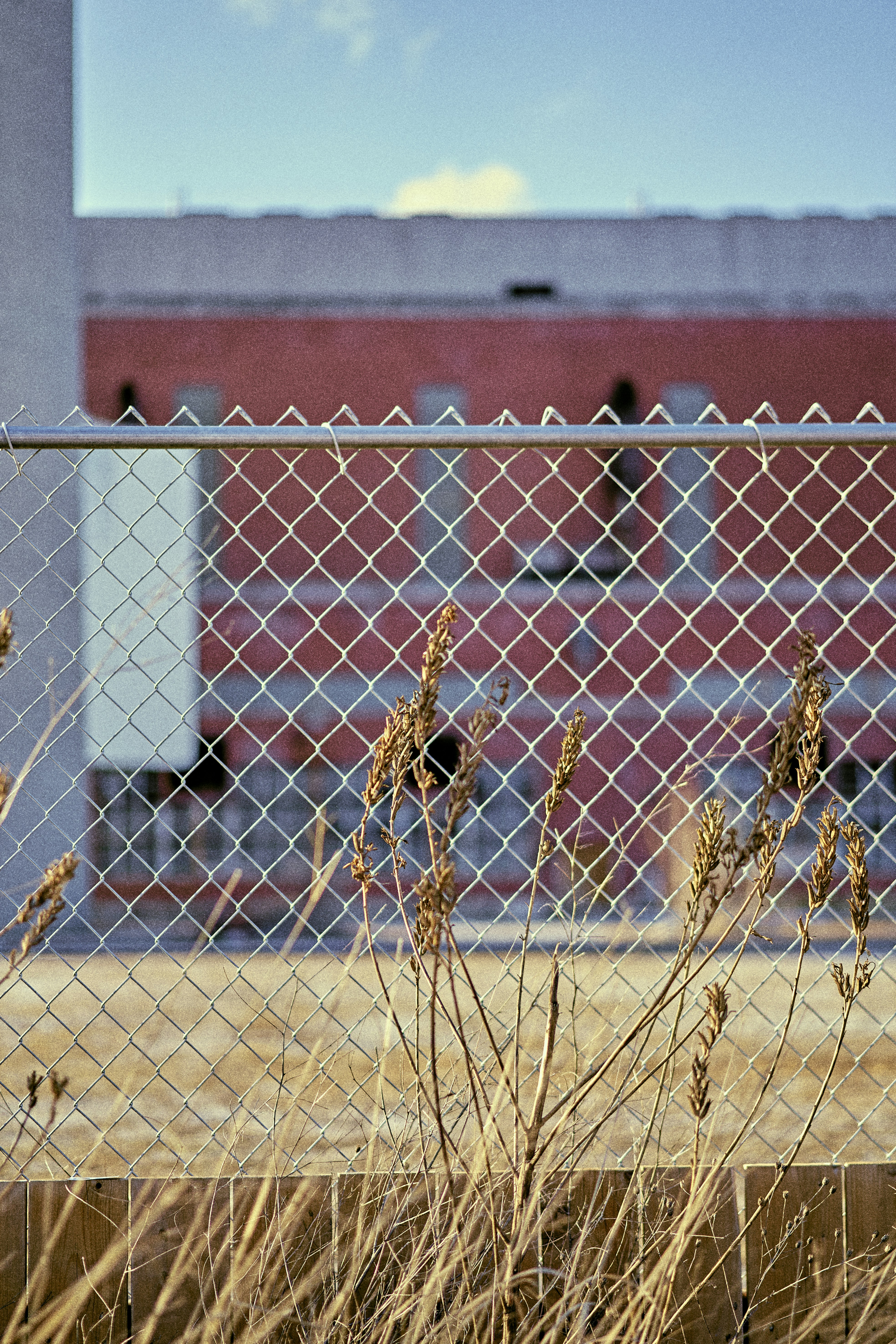 a red building behind a chain link fence