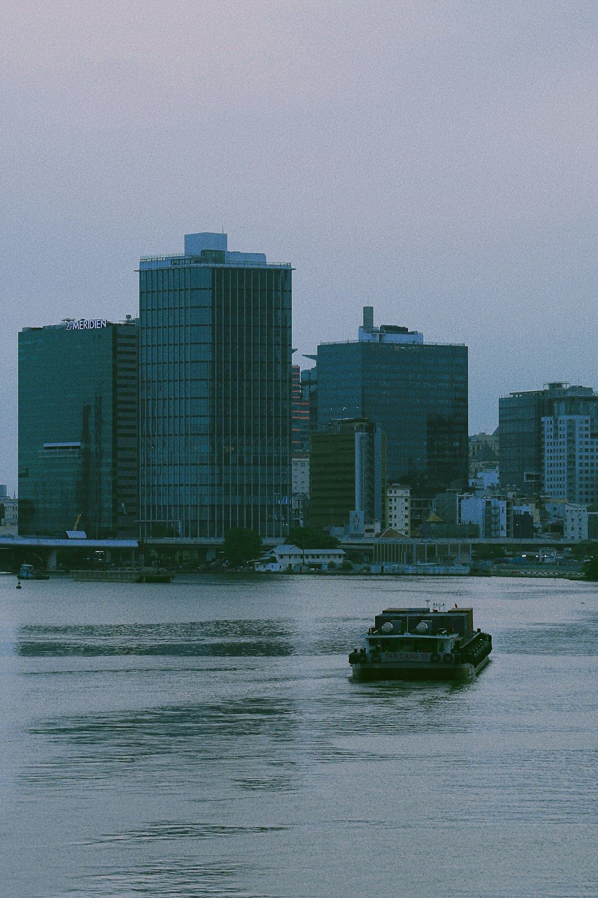 Ho Chi Minh City October — the Saigon River at dusk as the wet season transitions, reflected lights on the river water