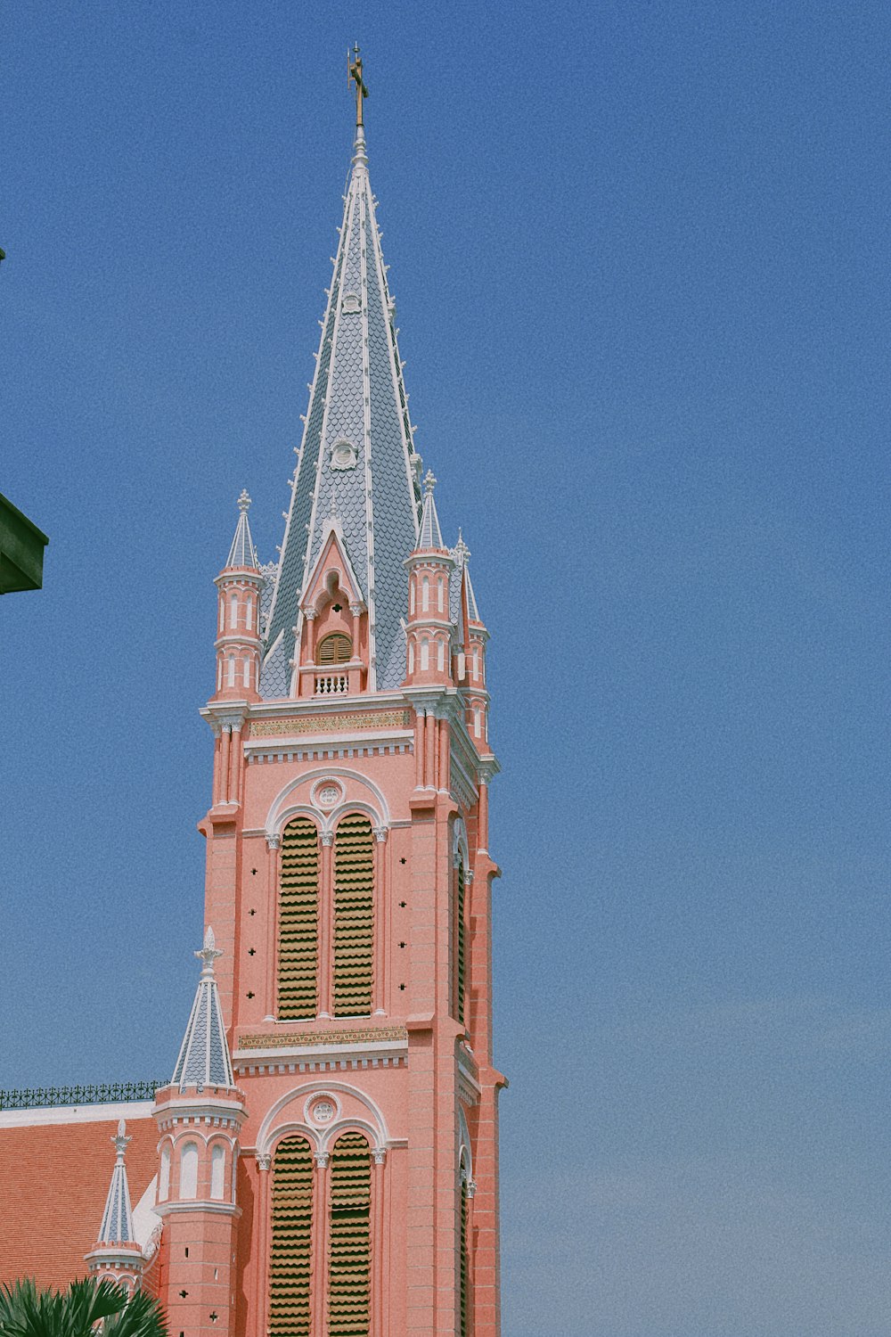a large pink building with a steeple and a clock