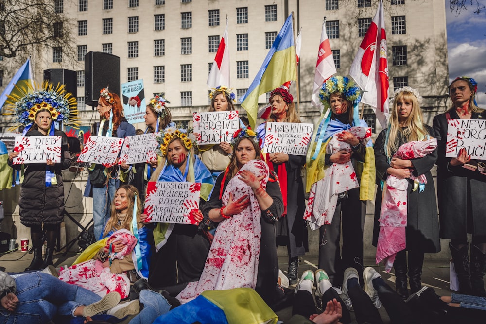 a group of people holding signs in front of a building